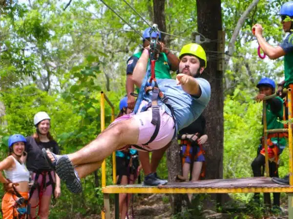 Man zip lining in costa rica during the rainy season